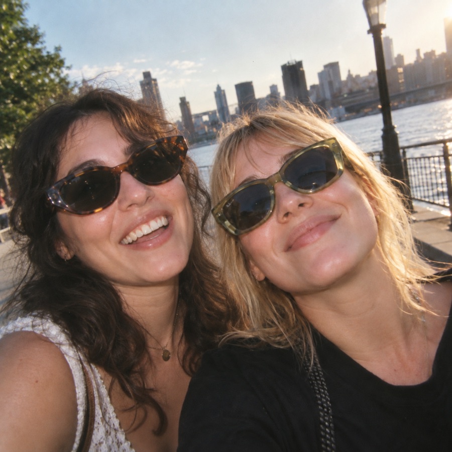 Two friends laughing together in the sunshine